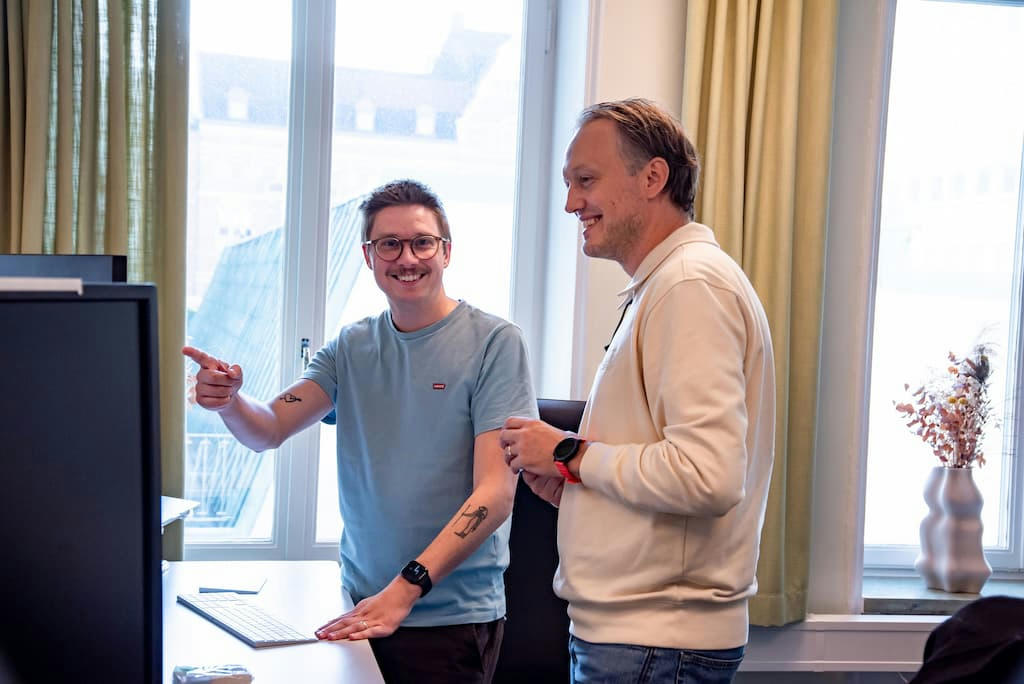 Glada app-programmerare vid sina skrivbord Glada app-programmerare vid sina skrivbord